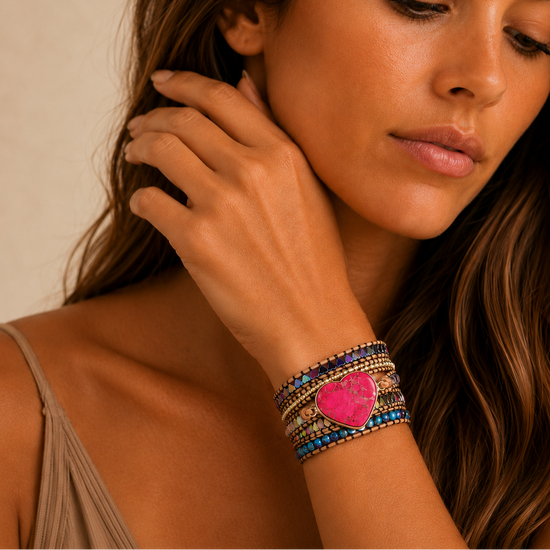 Woman wearing a colorful bracelet with a heart charm on her wrist.