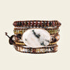 Multistrand bracelet with a large central stone on a beige background