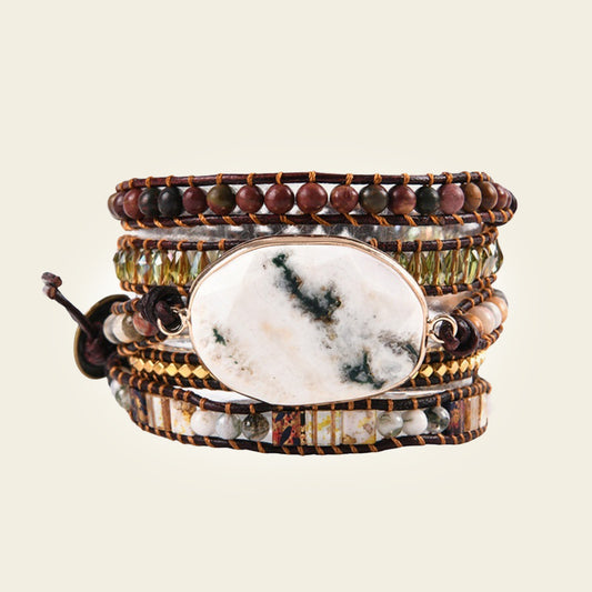 Multistrand bracelet with a large central stone on a beige background