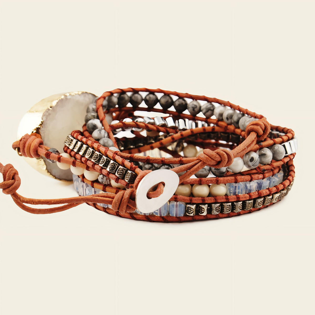 Multistrand bracelet with beads and leather wrap on a beige background
