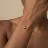 Gold bracelet on a wrist with a textured surface background