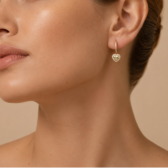 Close-up of a woman wearing a heart-shaped earring on a beige background