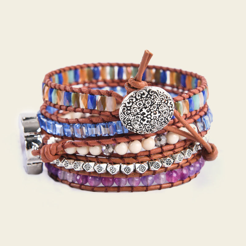 Stack of colorful beaded wrap bracelets with metal accents on a beige background