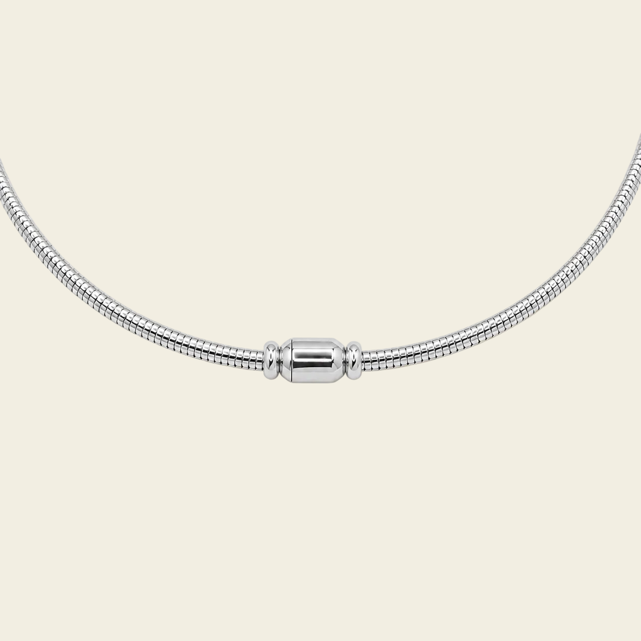 A silver snake chain necklace with a polished cylindrical clasp, displayed against a solid pale peach background.
