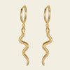 Gold hoop earrings with snake-like designs on a beige background