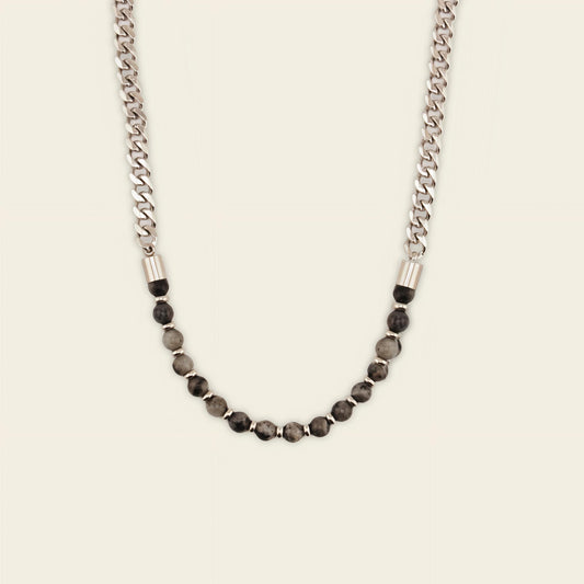Necklace with chain and beaded design on a beige background