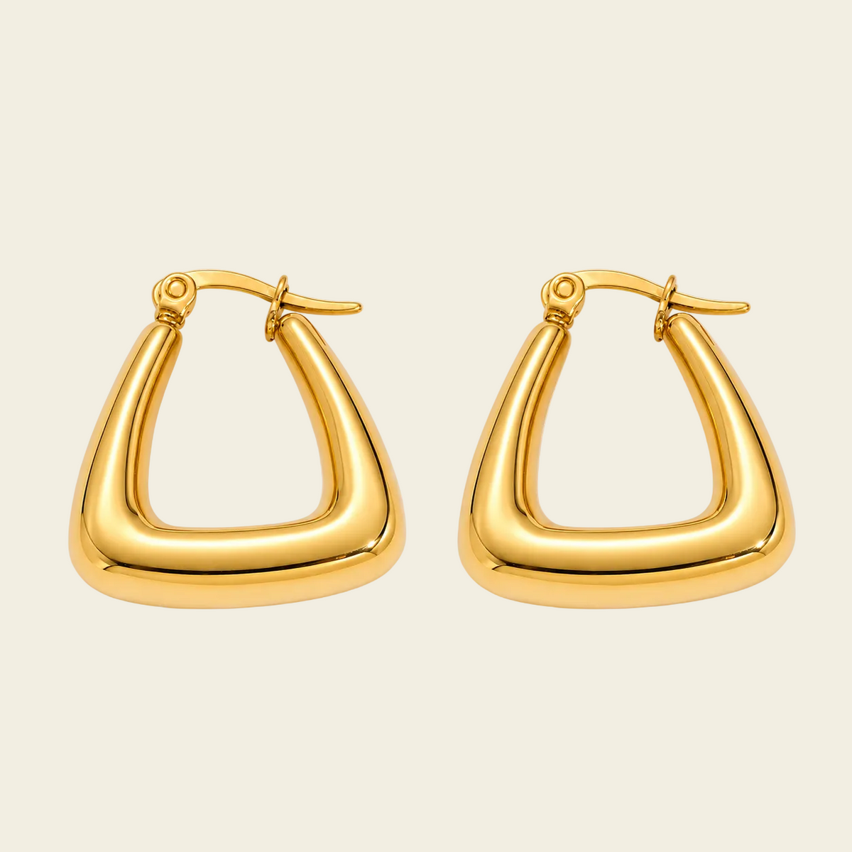 A pair of polished gold huggie hoop earrings with a thick, rounded triangular frame design, displayed on a clean, light beige background.