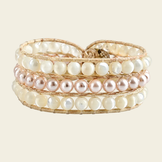 Stack of pearl wrap bracelets on a beige background