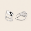 Pair of silver earrings on a beige background