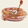 Stack of beaded bracelets with leather straps on a beige background