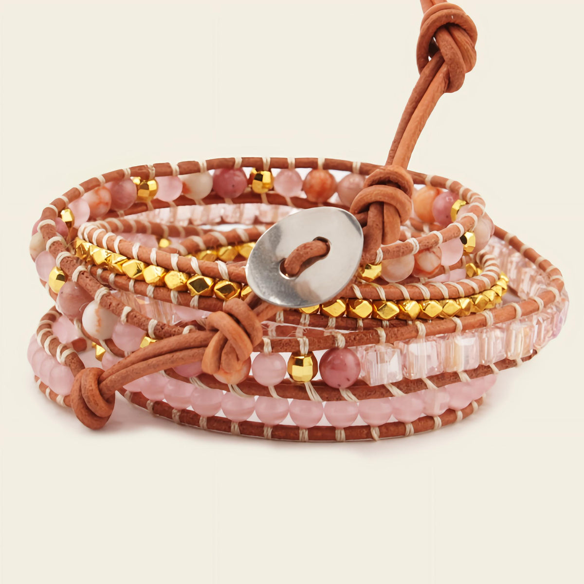 Stack of beaded bracelets with leather straps on a beige background