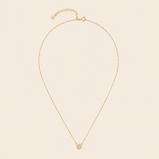 Gold necklace with a pendant on a beige background