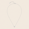 Silver necklace with a small round pendant on a beige background