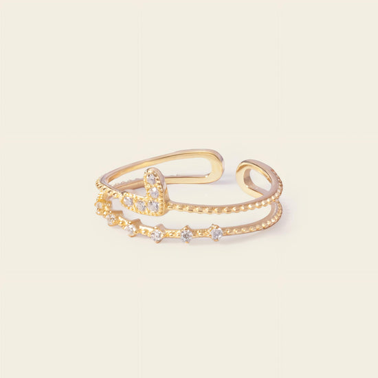 Gold open bracelet with star-shaped stones on a light beige background