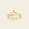 Gold open ring with small stones on a beige background