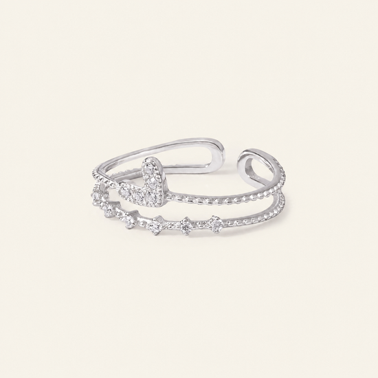 Silver ring with small diamonds on a light beige background