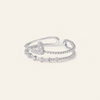 Silver ring with small diamonds on a light beige background