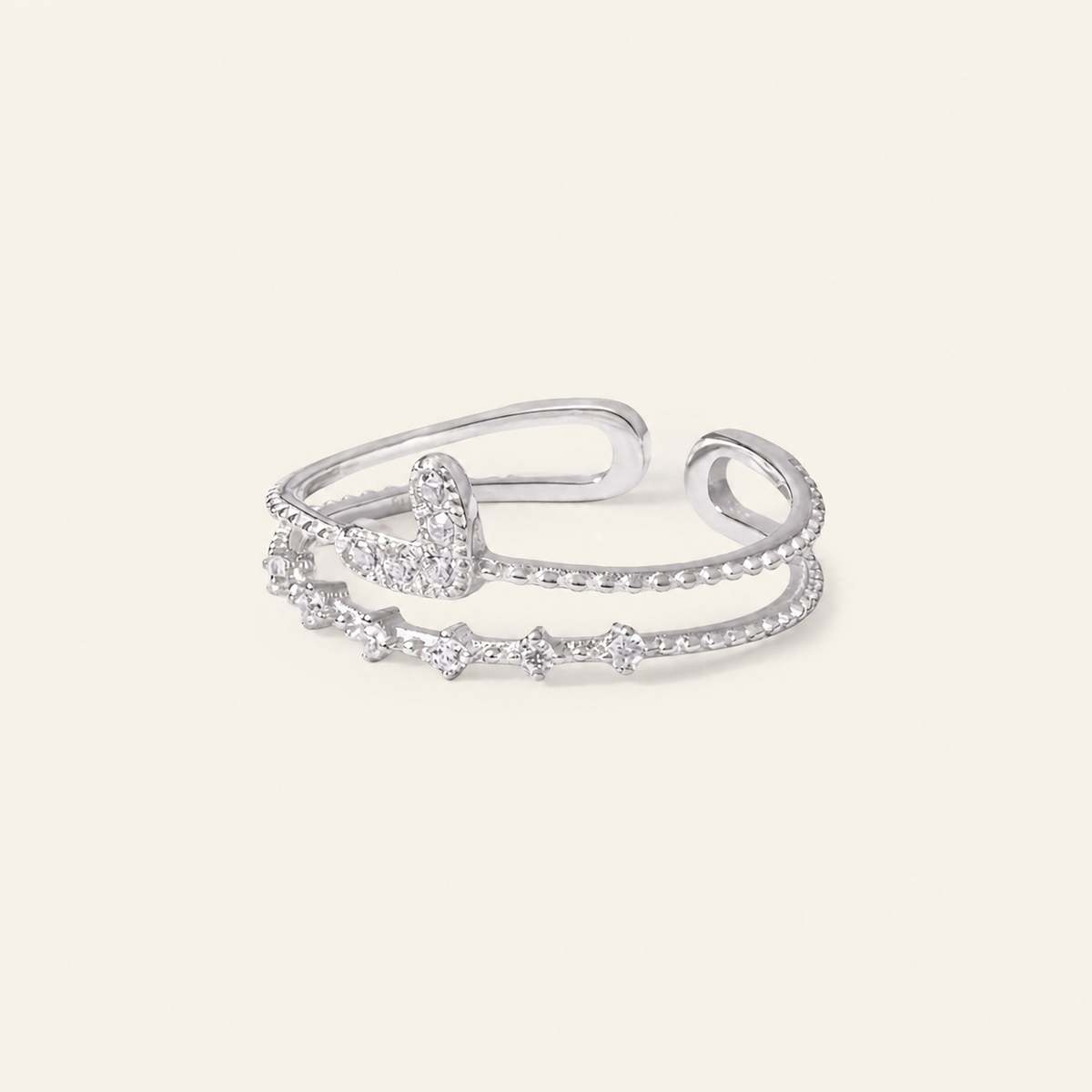 Silver ring with small diamonds on a light beige background