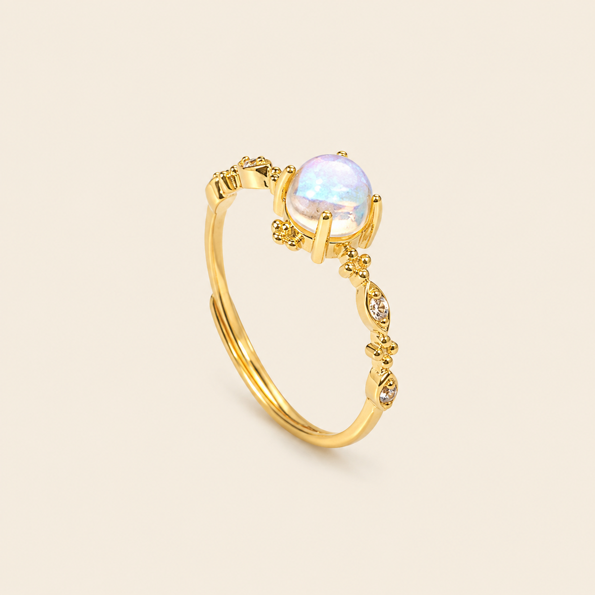 Gold ring with a white gemstone on a beige background