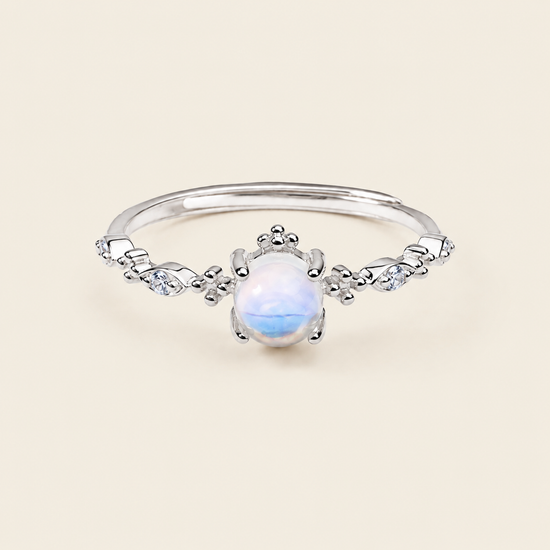 Silver ring with a white gemstone on a beige background