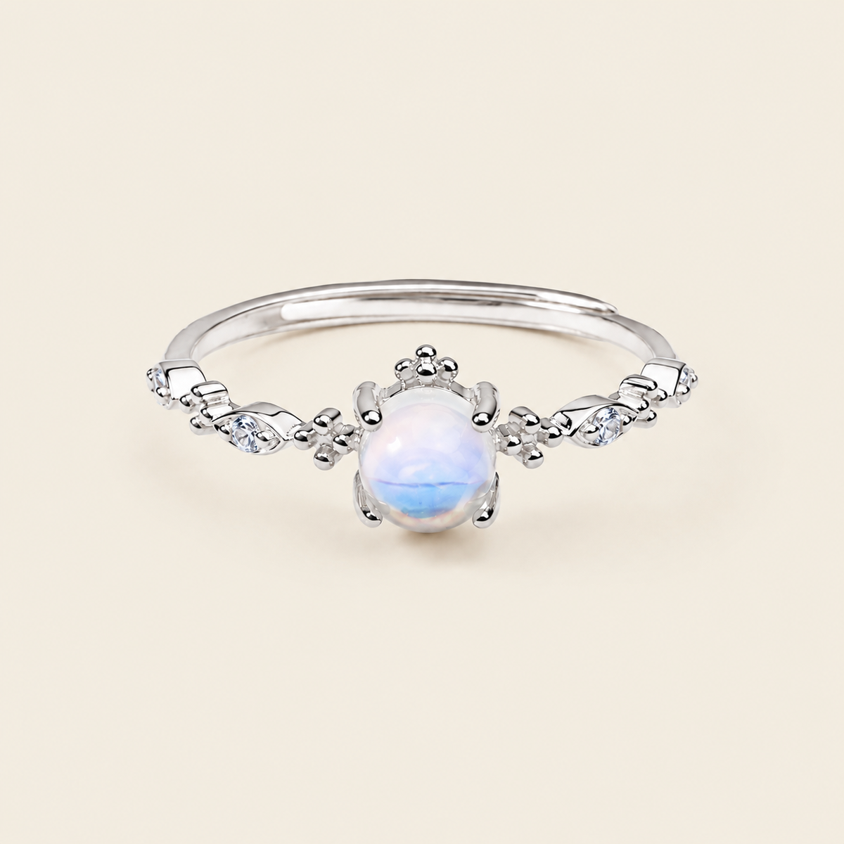 Silver ring with a white gemstone on a beige background