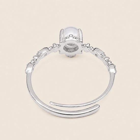 Silver ring with a central gemstone on a beige background