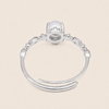 Silver ring with a central gemstone on a beige background