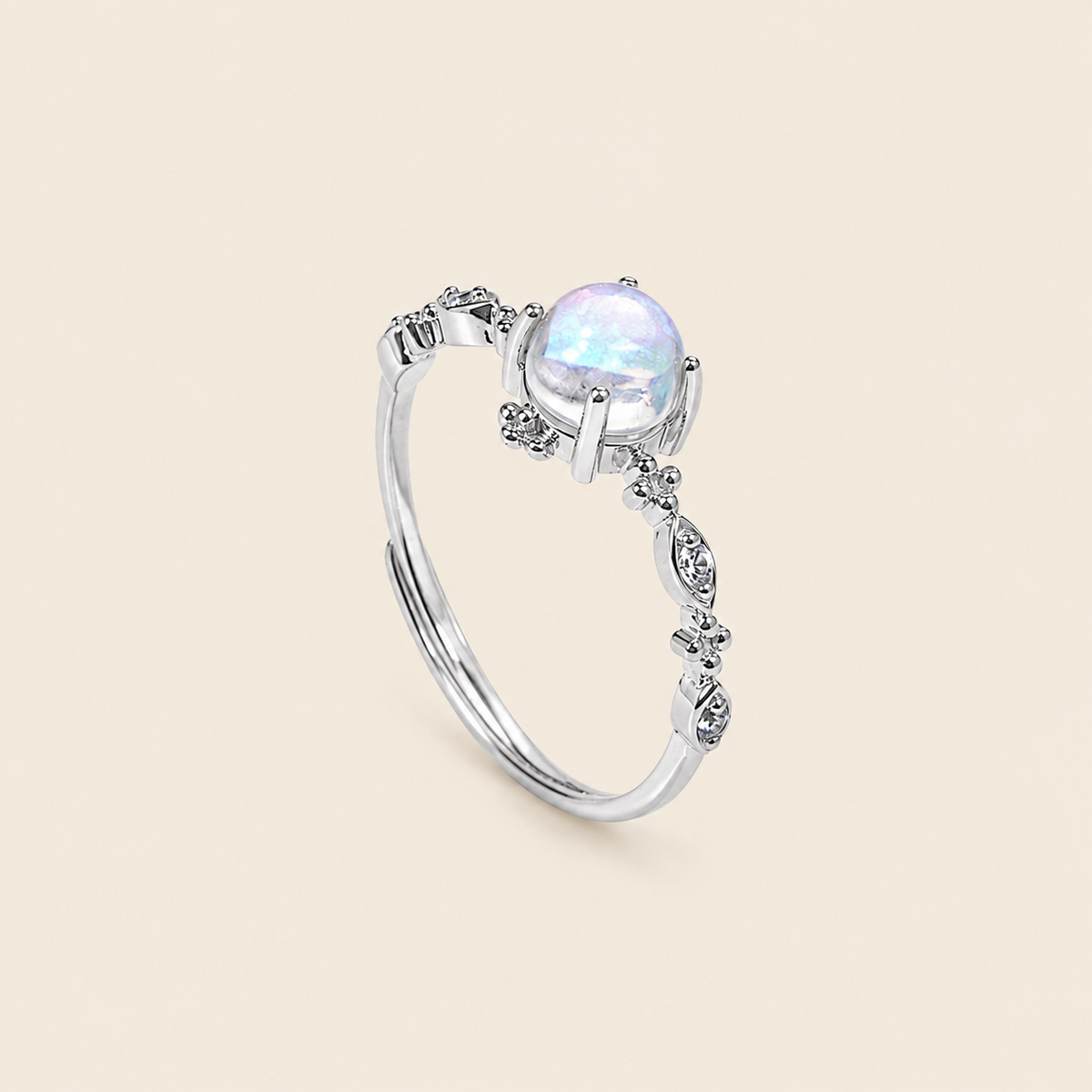 Silver ring with a white gemstone on a beige background