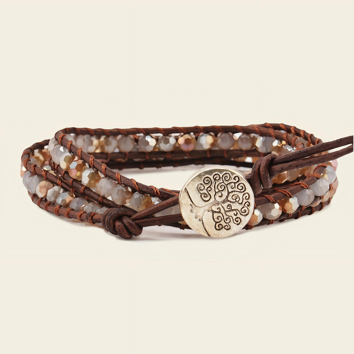 Multistrand bracelet with beads and a metal charm on a beige background