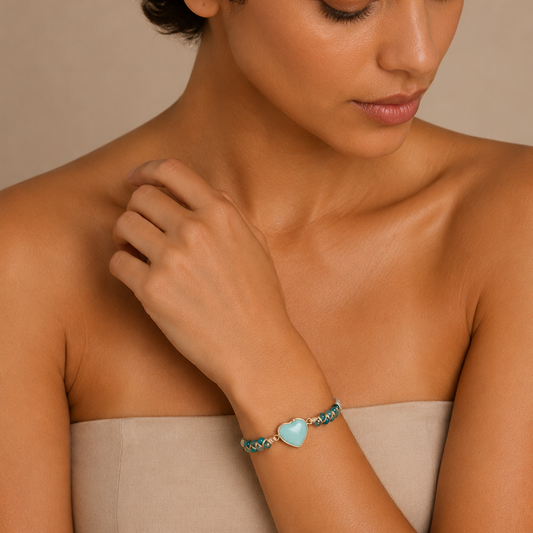Woman wearing a bracelet with a heart-shaped charm on a beige background