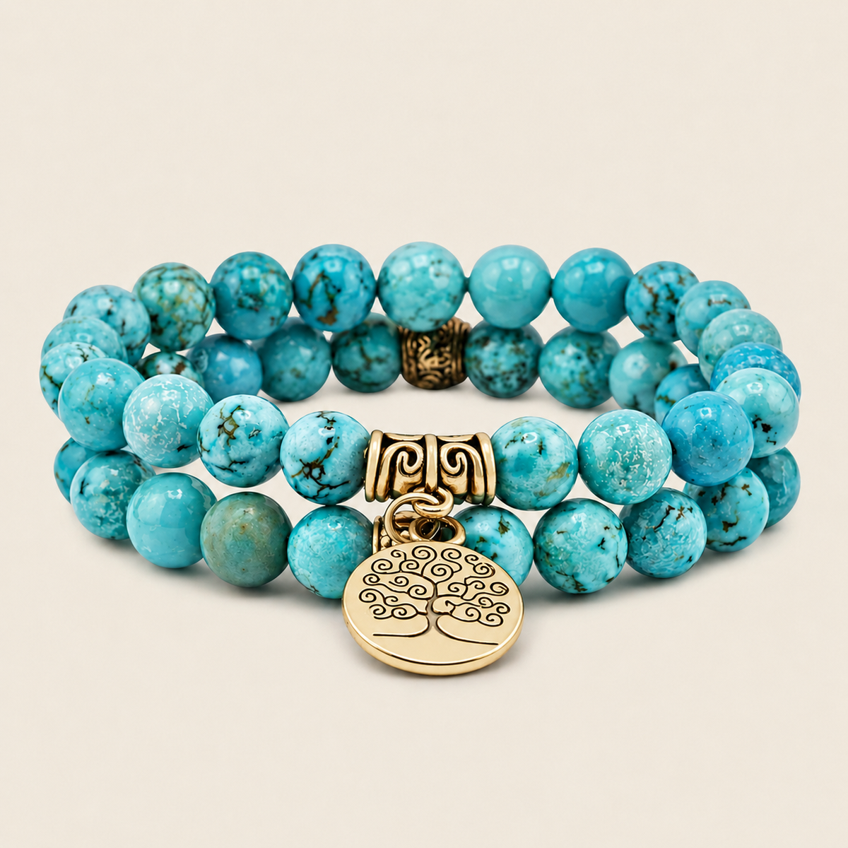 Turquoise beaded bracelet with gold tree of life charm on a beige background