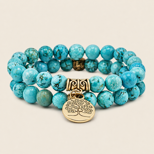 Turquoise beaded bracelet with gold tree of life charm on a beige background