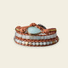 Stack of beaded bracelets with a central turquoise stone on a beige background