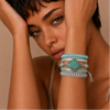 Woman wearing a turquoise and silver bracelet on a beige background