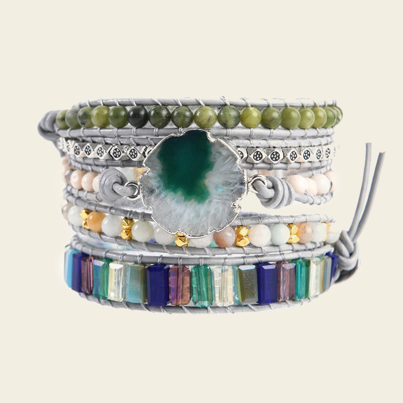 Multistrand bracelet with beads and a central stone on a beige background