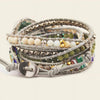 Multistrand beaded bracelet with gray leather strap on a light background
