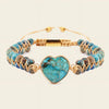 Turquoise beaded bracelet with a heart-shaped turquoise charm on a beige background