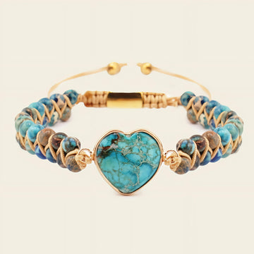 Turquoise beaded bracelet with a heart-shaped turquoise charm on a beige background