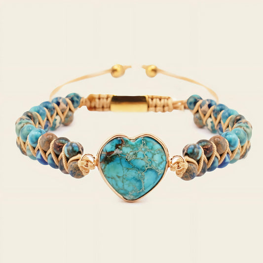 Turquoise beaded bracelet with a heart-shaped turquoise charm on a beige background