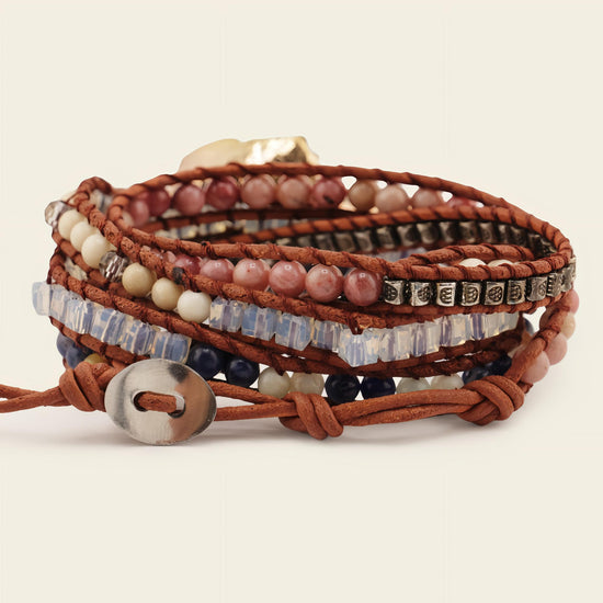 Multistrand bracelet with beads and leather strap on a light background