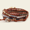 Multistrand bracelet with beads and leather strap on a light background
