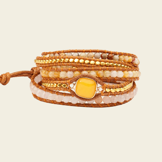 Multistrand beaded bracelet with a yellow stone on a beige background
