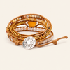 Multistrand beaded bracelet with a silver charm on a beige background