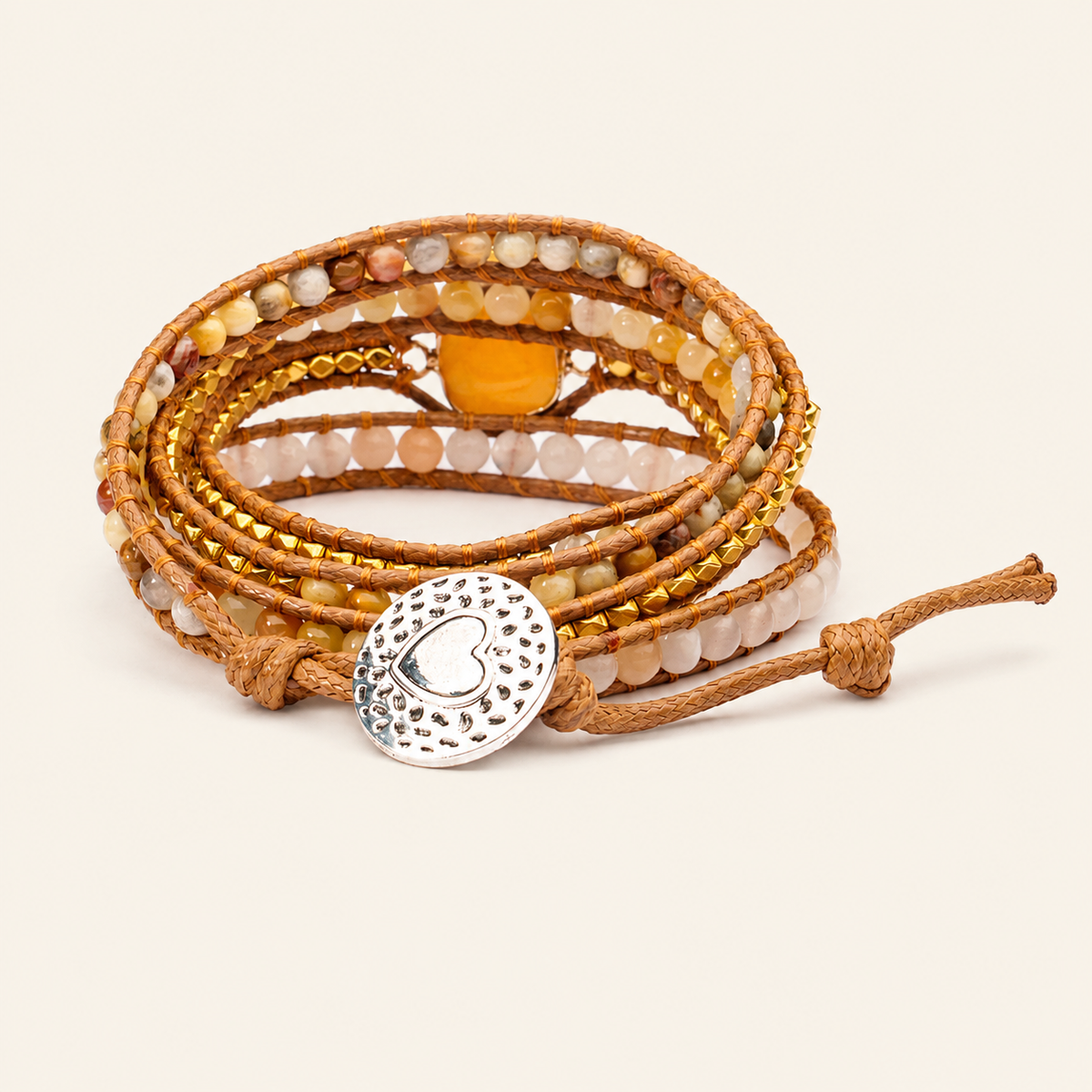 Multistrand beaded bracelet with a silver charm on a beige background