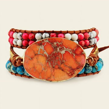 Multistrand bracelet with an orange stone centerpiece on a light background