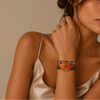 Woman wearing a colorful beaded bracelet on a neutral background