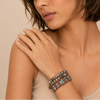 Close-up of a woman's arm wearing a bracelet with a neutral background