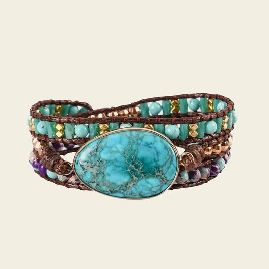 Multistrand beaded bracelet with a large turquoise stone on a beige background