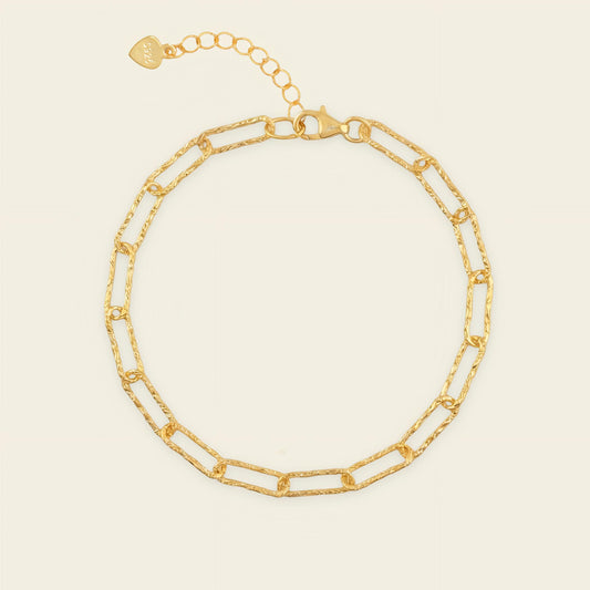 Gold chain bracelet on a beige background