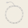 A silver chain link bracelet with elongated oval links and a lobster clasp, shown on a light beige background.